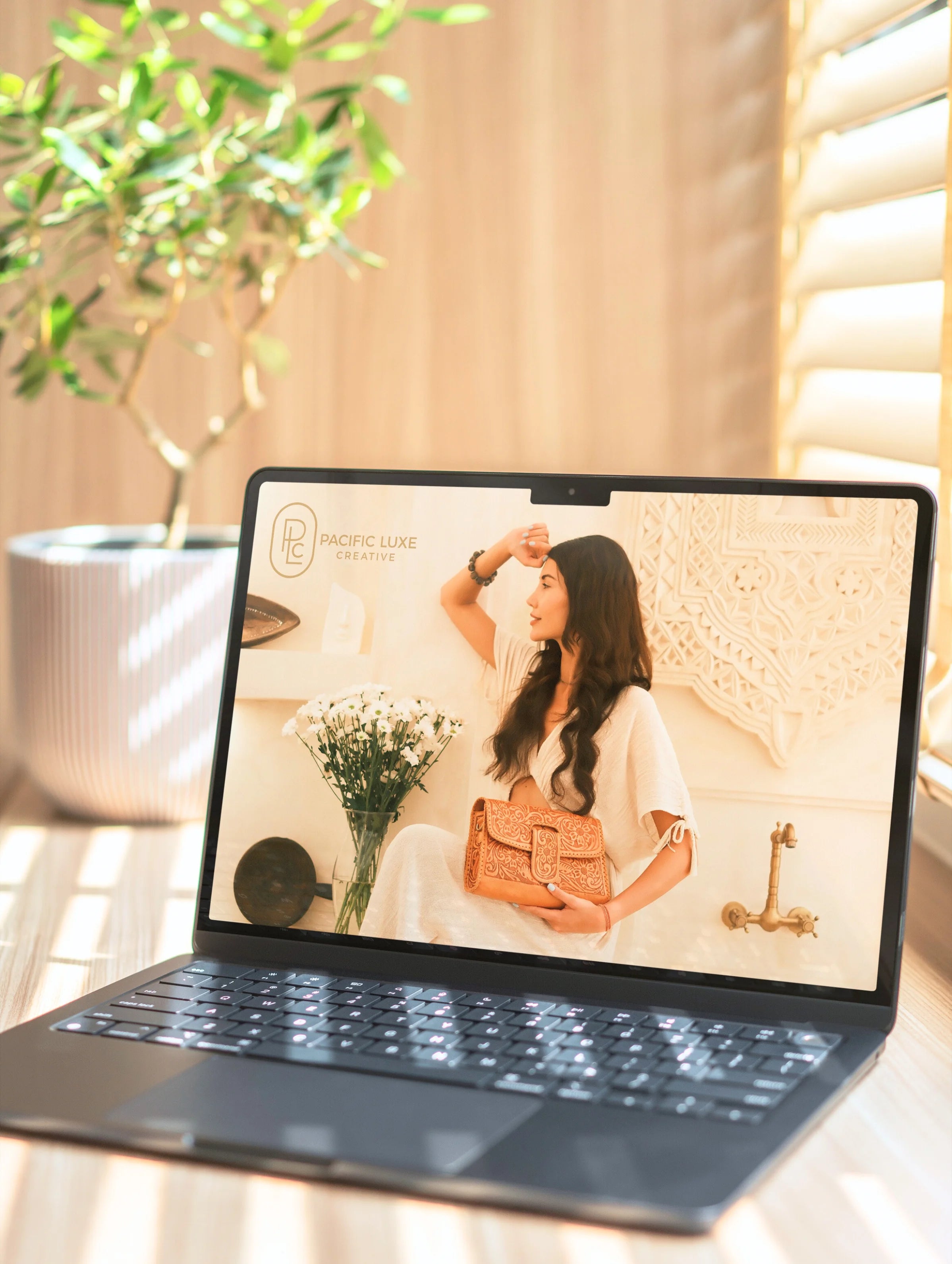 Luxury product photography by Pacific Luxe Creative, featuring a handbag image on a laptop screen with a blurred background.