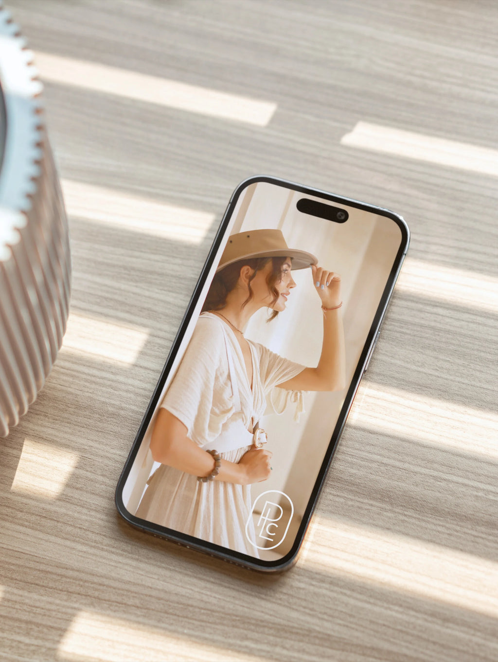 Pacific Luxe Creative product photography phone case featuring a woman wearing a hat on a wooden surface with soft luxury glow.