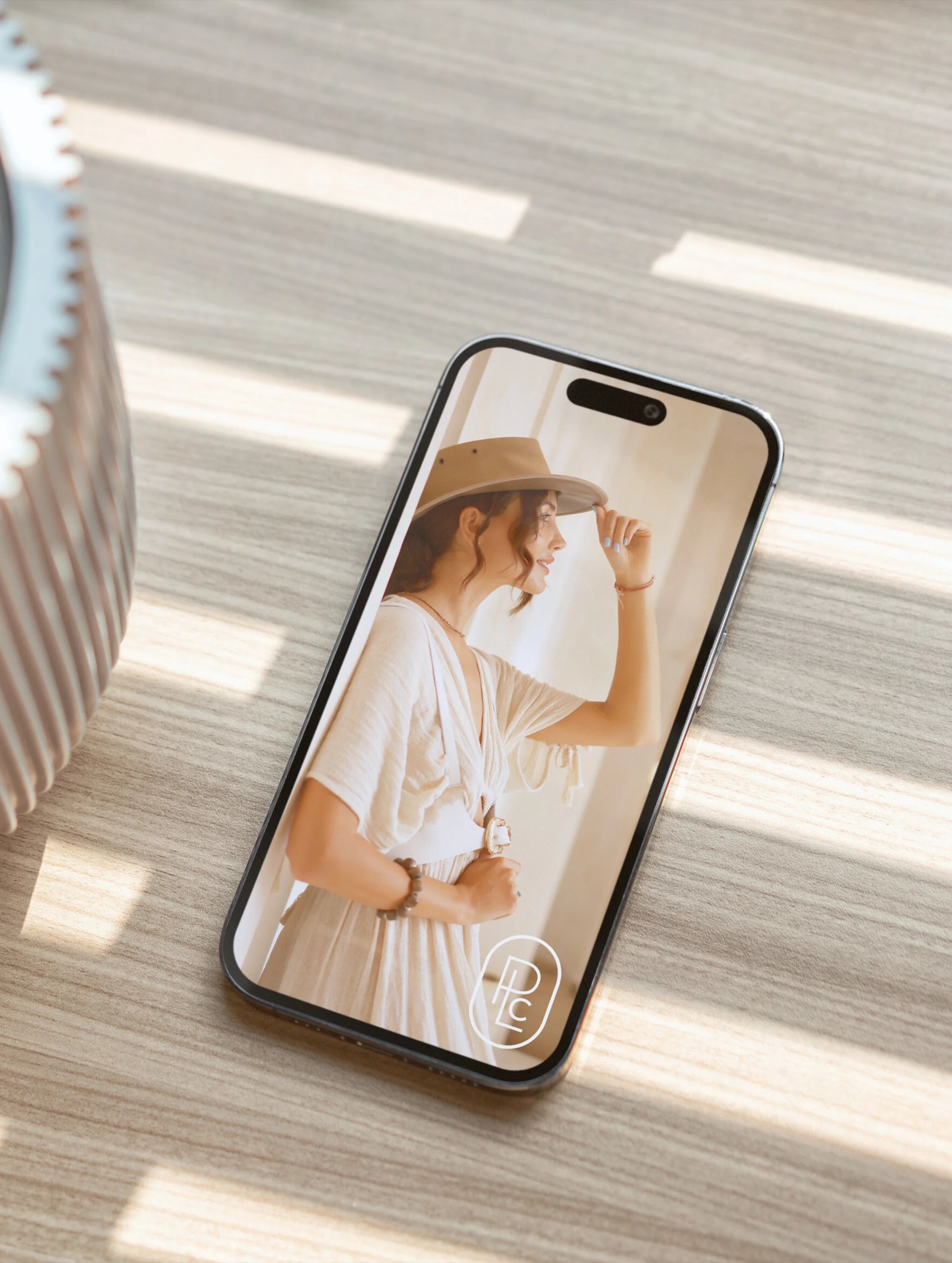 Pacific Luxe Creative product photography phone case featuring a woman wearing a hat on a wooden surface with soft luxury glow.