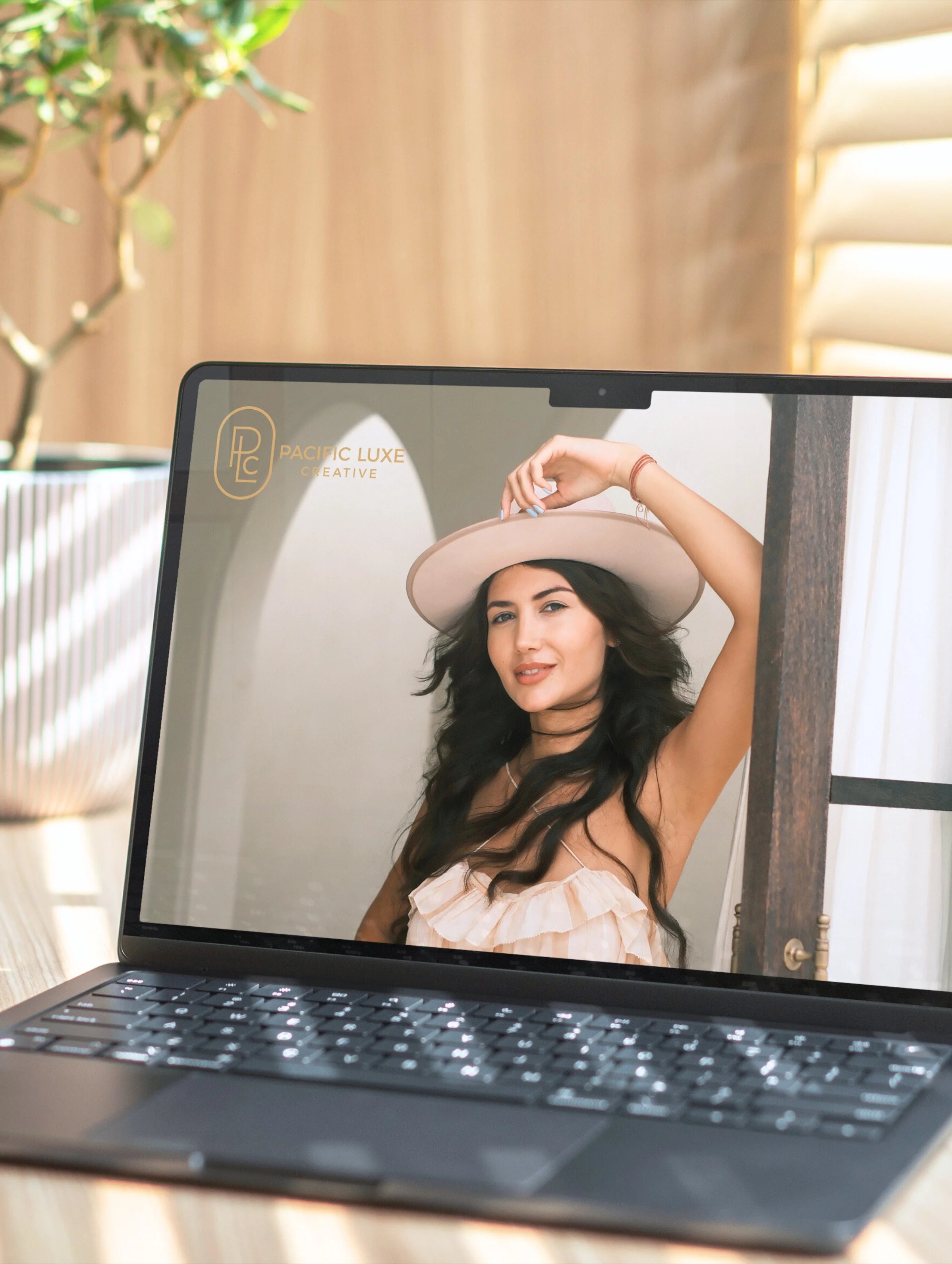 Luxe product photography by Pacific Luxe Creative featuring elegant portrait of a woman in a hat on laptop screen, styled with Perth-inspired tones.
