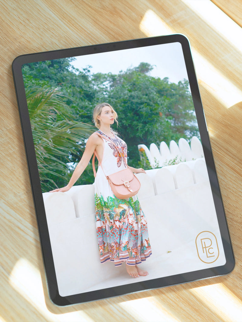 Elegant product photography from Pacific Luxe Creative floral dress and pink bag displayed on tablet, styled with tropical luxe sophistication.
