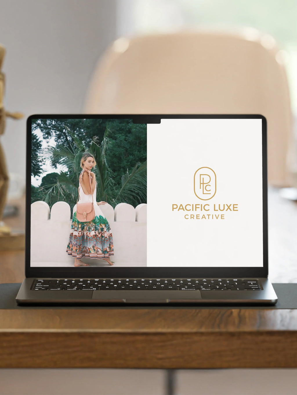 Creative Island Luxe imagery laptop on wood showing woman and Pacific Luxe Creative logo under natural Perth light.