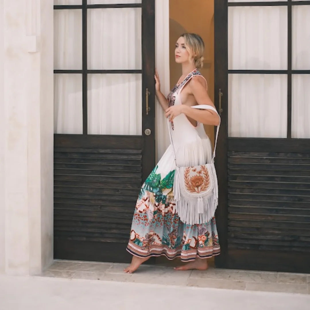 Woman in a colorful dress with a floral pattern standing in front of a door showcasing pacific luxe creative vibes