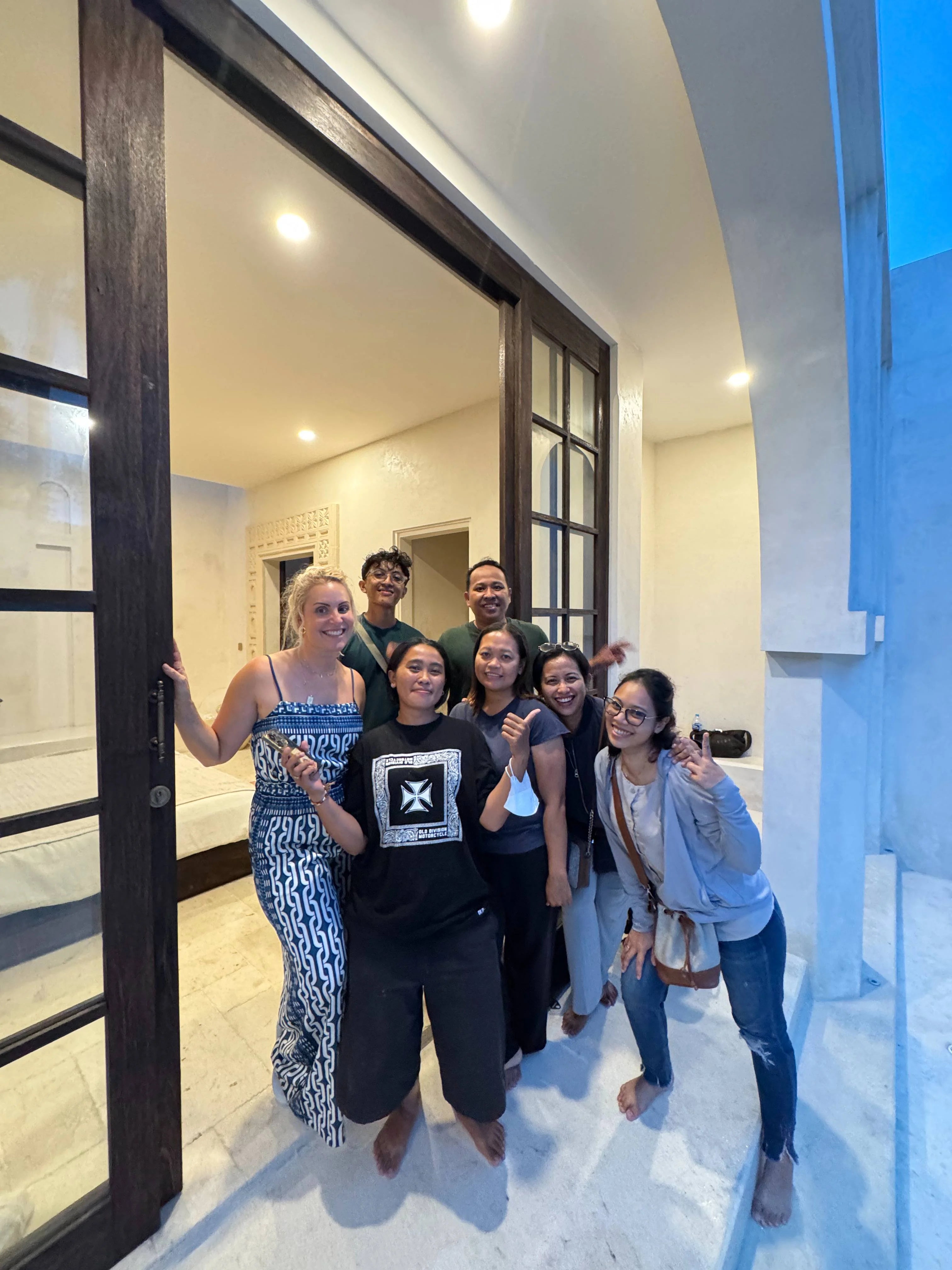 pacific luxe creative team posing in a modern interior setting with large glass doors.