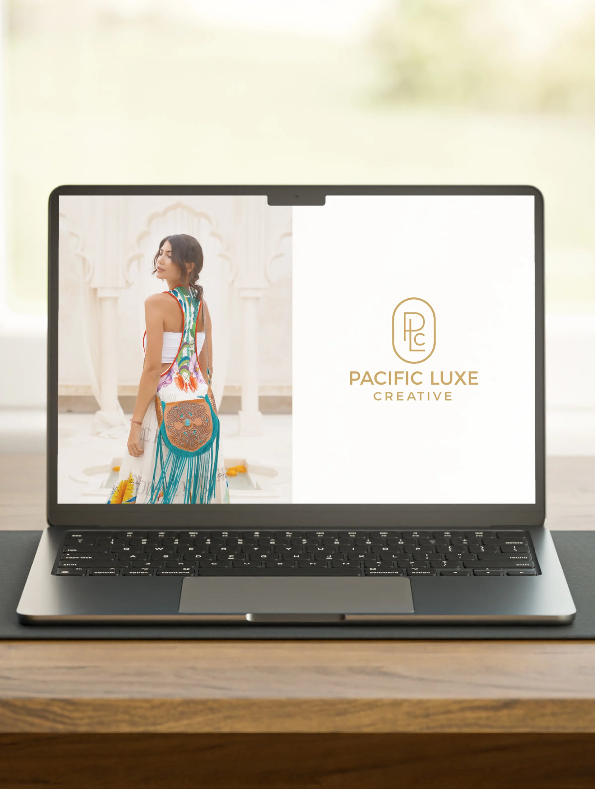 Creative Bali-inspired brand scene laptop showing woman in colorful dress and logo under soft palm breeze light.